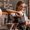 barista pouring coffee in cafe
